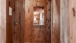A narrow hallway with wooden walls and a wooden ceiling.