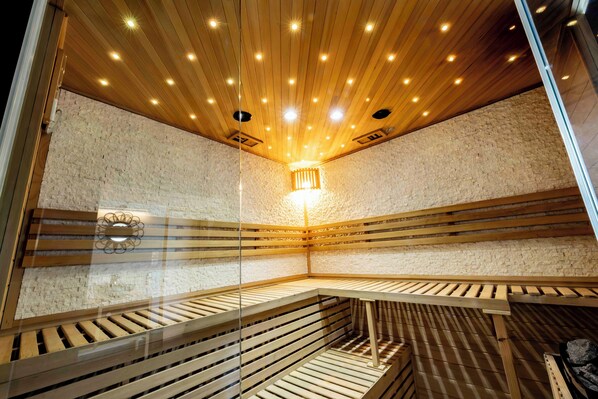 Una sauna con listones de madera y un interior de pared de piedra.