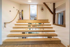Un escalier en bois offrant une vue sur une pièce située à l’étage supérieur.