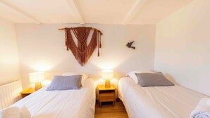A hotel room with two single beds, each with a bedside lamp and a pillow. - Gîte L'instant Vosges, private wellness area (Aydoilles)