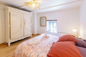 A bedroom with a bed, a wardrobe, a window, and a lamp. - Gîte L'instant Vosges, private wellness area (Aydoilles)