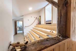 A wooden staircase with a rustic design, leading to a bedroom with a large window. - Gîte L'instant Vosges, private spa area (Aydoilles)