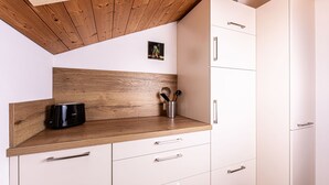 Una cucina con mobili in legno, una macchina da caffè e un portauova.