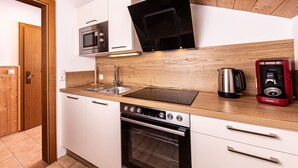 Una cucina moderna con piano di lavoro in legno, elettrodomestici in acciaio inossidabile e forno integrato.