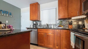 A kitchen with wooden cabinets, a stainless steel refrigerator, and a coffee maker.