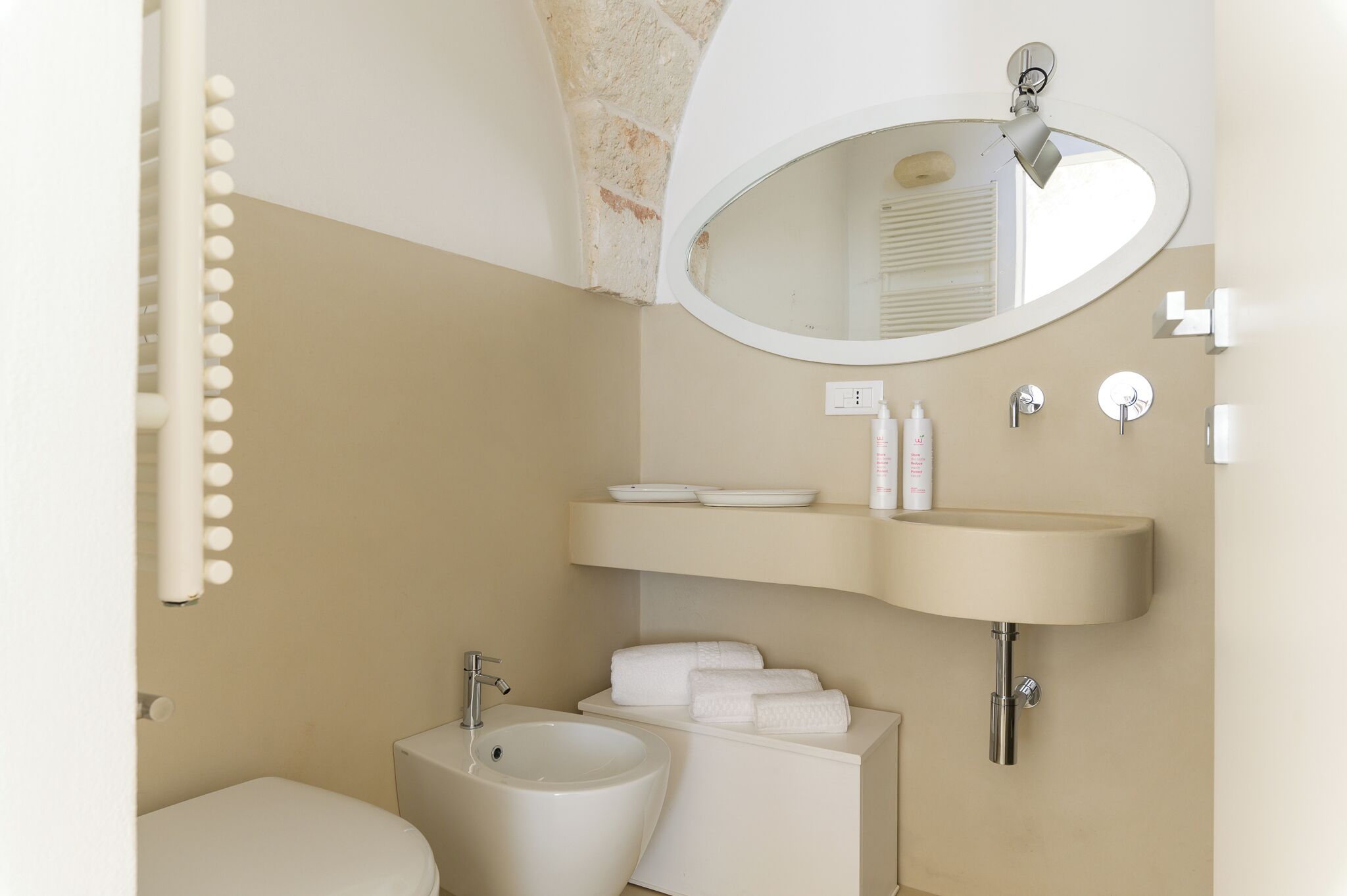 A bathroom with a sink, mirror, and toilet.