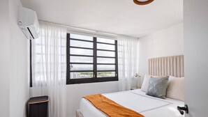 Una camera da letto con un letto, una finestra con persiane, un comodino e un condizionatore.