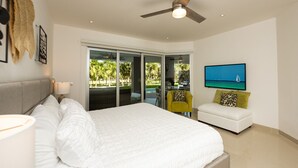 Camera da letto con un letto, una ventola a soffitto, una TV e vista sull'esterno.