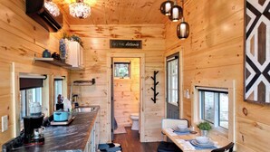 Een compact vakantiehuisje met een keuken, een eethoek, en een bordje met de tekst 'GO THE distance'.