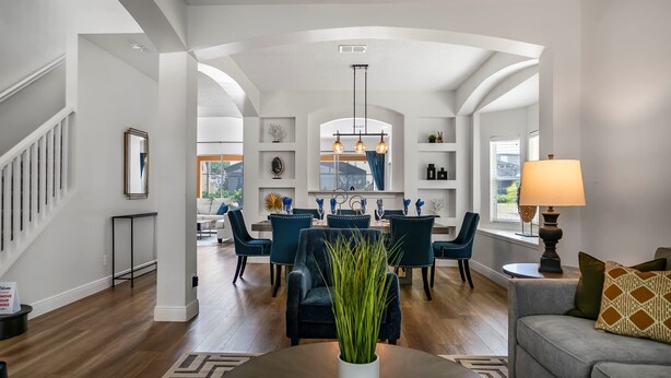 A spacious living room with a dining area, featuring a staircase, a chandelier, and a view of the outdoors. - Avatar | 2.5 Mi Disney | Pool | Game Room 8510 (Kissimmee)