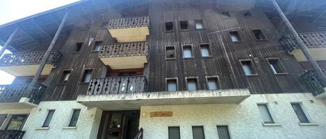A multi-story building with a central entrance, balconies, and a sign reading "Los Males."