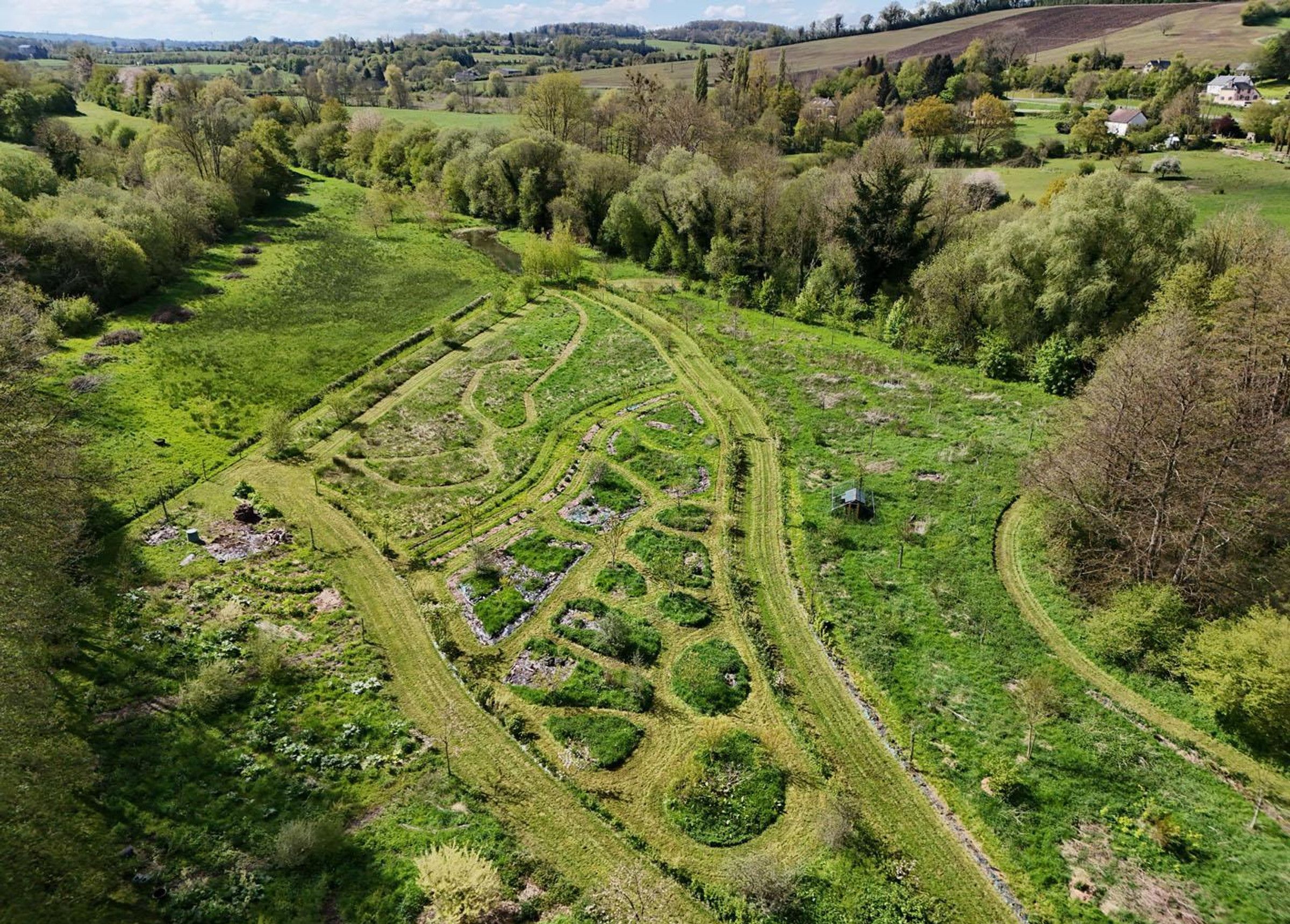 A rural landscape with terraced fields and a small house.
