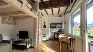 A compact living space with a TV, a dining area, and a kitchen.