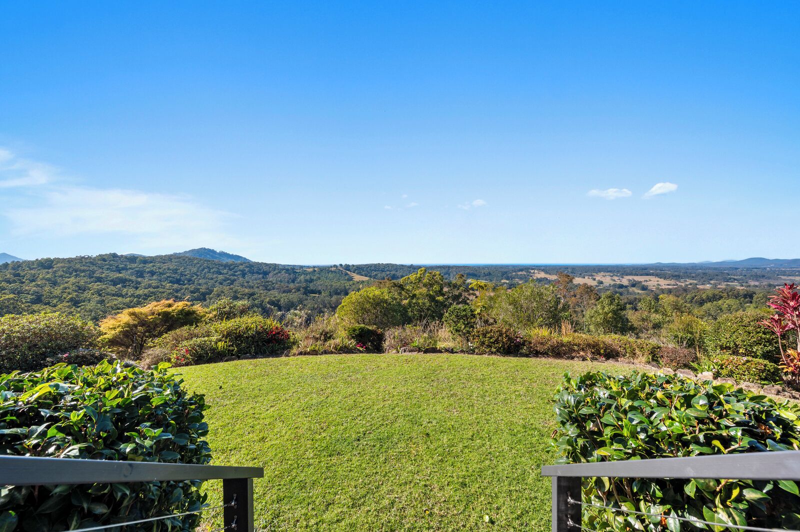 A grassy lawn with a view of distant hills and trees.