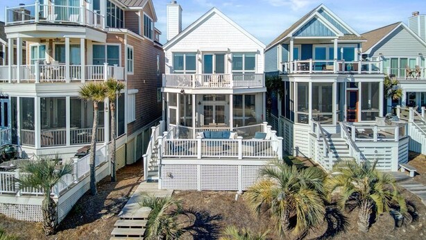 A beachfront property with multiple houses, each featuring balconies and large windows. - Oceanfront, Beachfront & Golf Views | 4BR in Ocean Point (Isle of Palms)