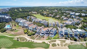 An aerial view of a coastal residential area with houses, a golf course, and a large hotel. - Oceanfront, Beachfront & Golf Views | 4BR in Ocean Point (Isle of Palms)