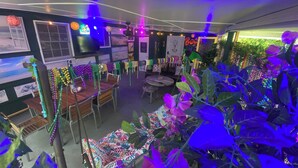 A room with a dining area, a sofa, and a table with colorful lights. - Gulfport Beach Home By Casino (Gulfport)