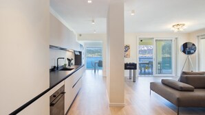 Una cocina moderna con comedor, sofá y vista al mar.