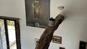 Une pièce comprenant une grande sculpture en bois, un tableau encadré accroché au mur et une petite plante en pot.