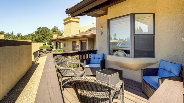 An outdoor patio with wicker furniture, a glass table, and a view of the surrounding area. - Sedona Condo on Golf Course w/ Pool Access! (Sedona)
