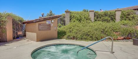 A hot tub with a sign indicating no swimming and a pool and spa rules sign.