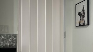 Une cuisine équipée d’une machine à café intégrée, d’un meuble blanc et d’un tableau encadré au mur.