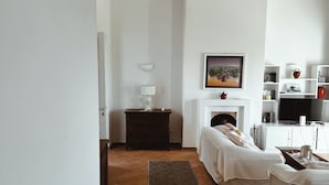 Ein modernes Wohnzimmer mit Kamin, Fernseher und Bücherregal.