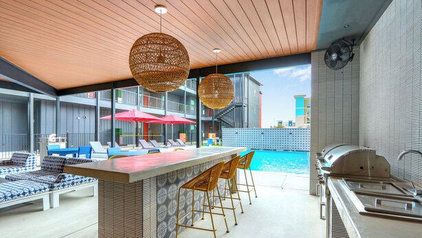 A poolside bar area with seating and a grill. - MCP Haus (New Braunfels)