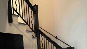 Eine Treppe mit schwarzen Geländern und weißen Stufen.