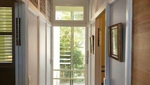 Un couloir doté d’un plancher en bois, de murs blancs et d’une grande fenêtre au fond.