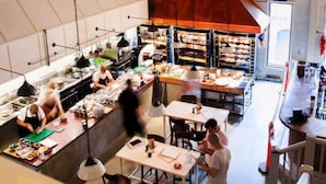Une cuisine moderne dotée de plusieurs postes de travail et de luminaires suspendus.