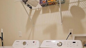 A front view of a white Samsung front-loading washer and dryer unit with a control panel on top. - 10 mins to Navarre Pier! Everything YOU need! (Navarre)