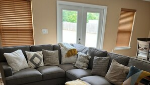 A L-shaped sectional sofa with multiple cushions, a matching ottoman, and a neutral-toned area rug. - 10 mins to Navarre Pier! Everything YOU need! (Navarre)