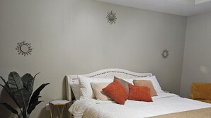 A bedroom with a bed, a potted plant, and decorative wall mirrors. - 10 mins to Navarre Pier! Everything YOU need! (Navarre)