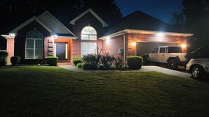 A two-story house with a garage, a driveway, and a well-maintained lawn. - Cozy Retreats of the cove  (Jackson)