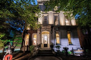 A historic building with a grand entrance, steps leading up to the door, and a sign indicating it is a bed and breakfast. - DuPont Mansion Bed & Breakfast (Louisville)