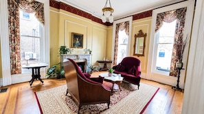 Une pièce avec une cheminée, un canapé, une table et une chaise.