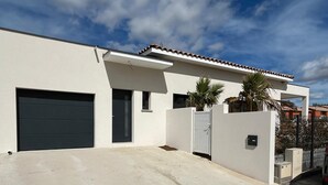 A modern house with a garage, a small entryway, and a covered driveway. - VILLA REVA with swimming pool, between land and sea (Nézignan-l'Évêque)