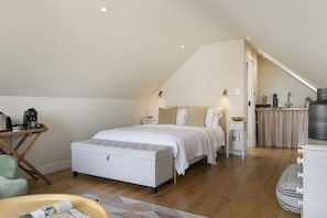 Un dormitorio con cama, mesita de noche y una pequeña zona de kitchenette.