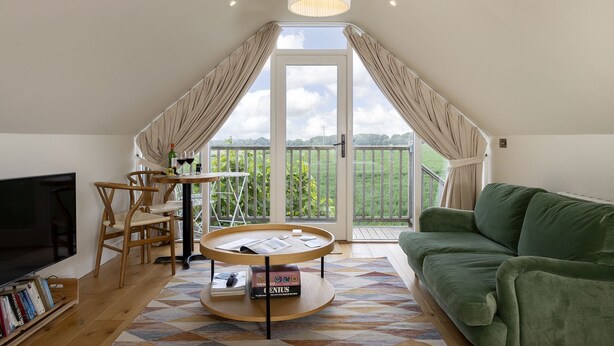 A cozy living room with a green sofa, a wooden coffee table, and a TV. - Cosy one bedroom apartment - Keepers Annexe (Cranham)