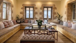Un salon chaleureux avec un canapé d’angle, une table basse et des coussins décoratifs.
