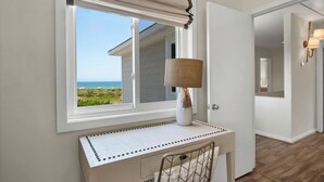 A room with a desk, a lamp, and a view of the ocean. - Ocean Views, Beach Access, Luxury Townhouse - Sleeps 10, Ping Pong! (Wrightsville Beach)
