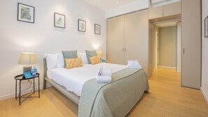 Une chambre d’hôtel comprenant un lit, des tables de chevet, une armoire et des œuvres d’art encadrées accrochées au mur.