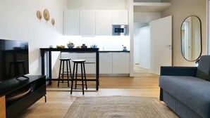A modern apartment with a kitchen, a dining area, and a living room.