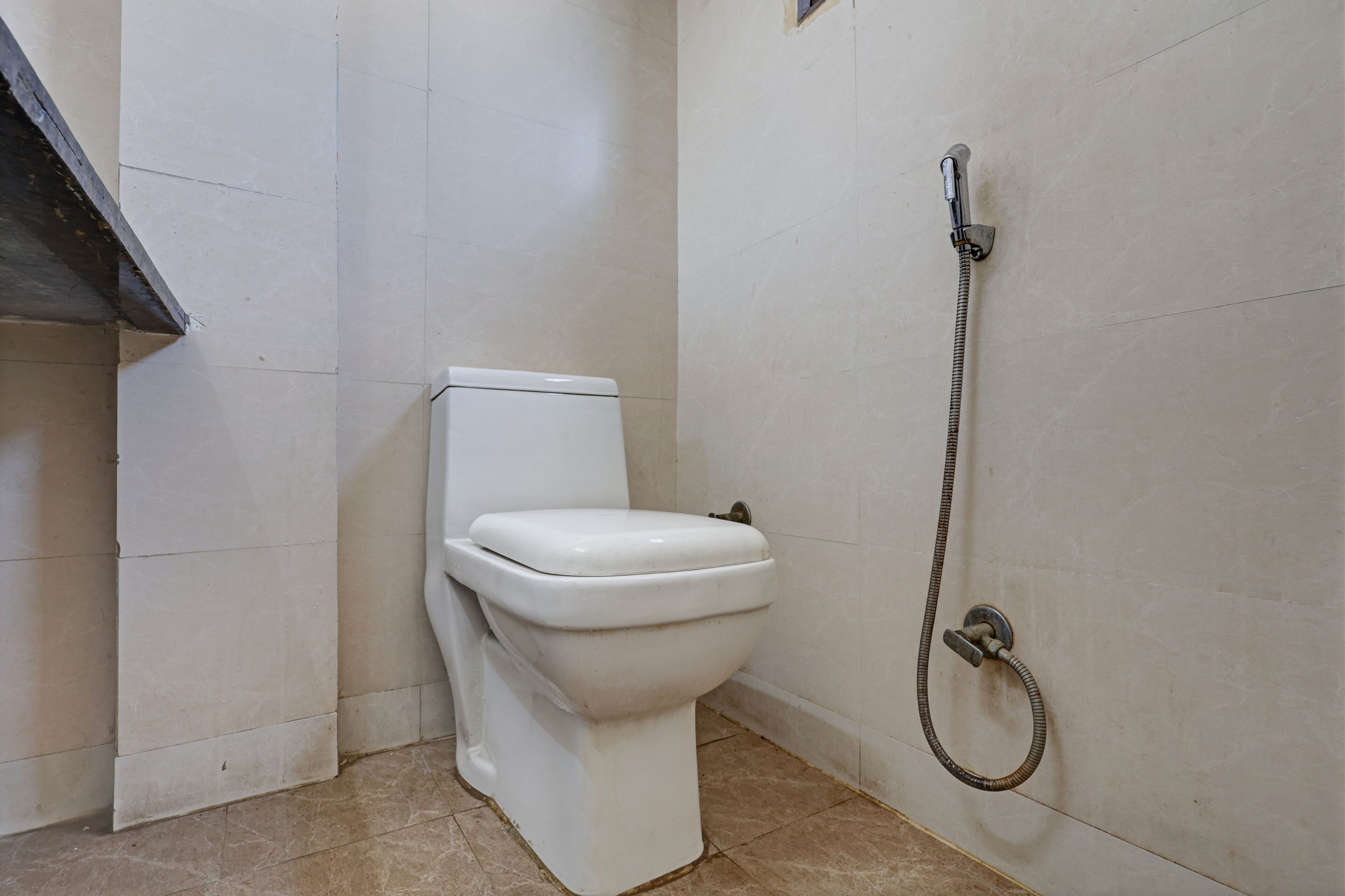 Ein Badezimmer mit Toilette, Dusche und Fliesen.