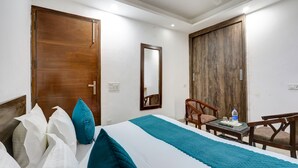 A hotel room with a bed, a desk, a chair, and a large mirror. - Mauryan Elite Hotel Qutab Minar Metro Station (New Delhi)