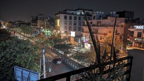 Une vue nocturne d’une ville, avec ses bâtiments, une rue et un pont.