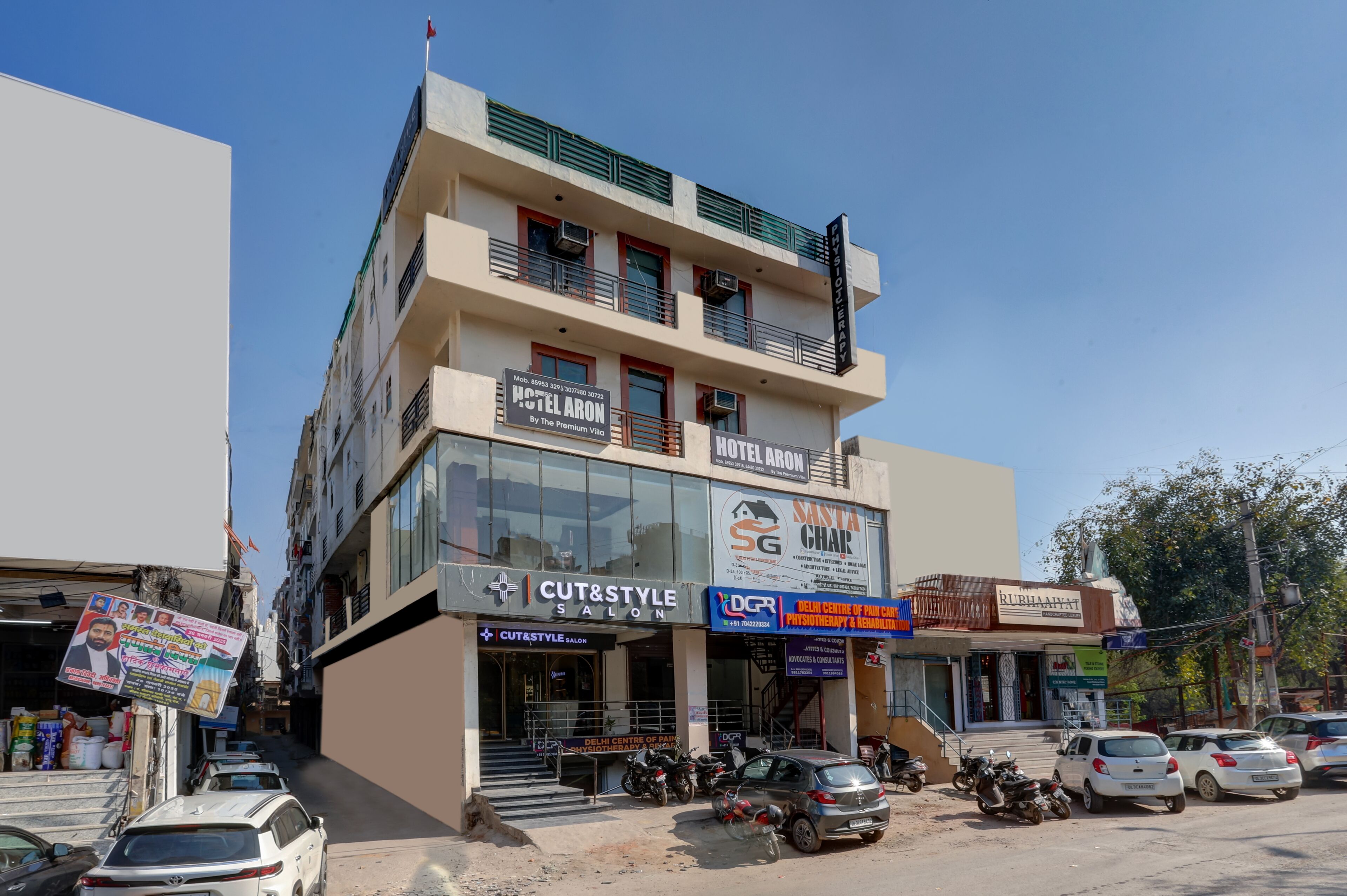 Un immeuble à plusieurs étages abritant divers commerces, notamment un hôtel, un salon de beauté et un garage automobile.