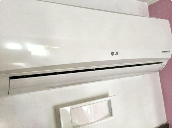 A white LG inverter air conditioner unit mounted on a wall.