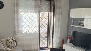 Ein modernes Wohnzimmer mit einem Glastisch, einer Couch und einem Fernseher.